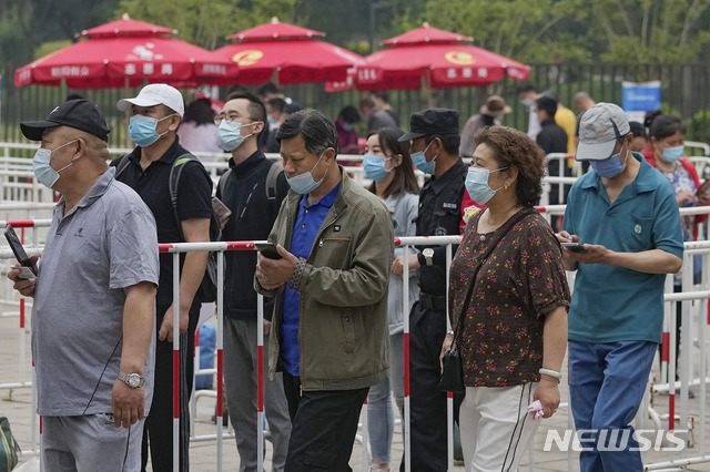 [베이징=AP/뉴시스]2일 중국 베이징에서 코로나19 확산을 막기 위해 마스크를 쓴 시민들이 중국의약집단 시노팜 백신을 접종하기 위해 줄 서 있다. 2021.06.02.
