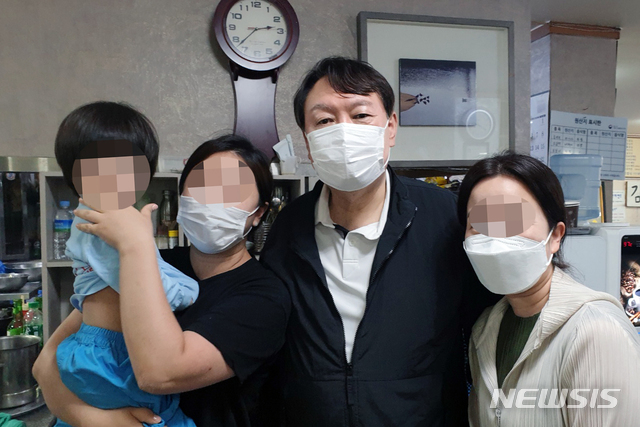 윤석열 전 검찰총장이 지난 29일 오후 강원도 강릉시 금학동 단골 식당 '감자바우'에서 시민들과 포즈를 취하고 있다. (출처: 뉴시스)