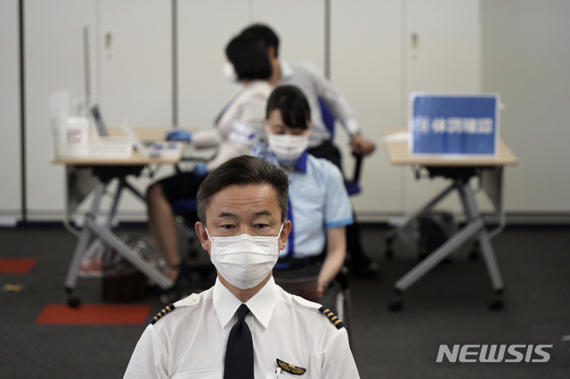 일본 최대 항공사 ANA 승무원들이 13일 도쿄 하네다 공항에 있는 접종센터에서 코로나19 예방을 위해 모더나 백신을 맞고 있다. (출처: 뉴시스)