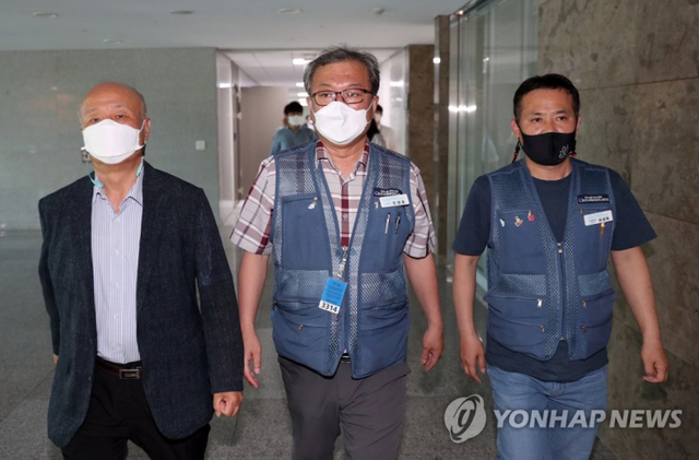 진경호 전국택배노동조합 위원장(가운데), 유성욱 택배노조 CJ대한통운본부장(오른쪽), 박석운 한국진보연대 공동대표 등이 16일 국회 의원회관에서 열린 사회적 합의기구 회의 도중 휴식시간을 이용해 나오고 있다. (출처: 연합뉴스)