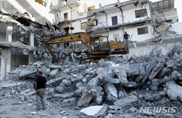 이스라엘 공습으로 파괴된 가자시티 건물[가자시티=AP/뉴시스] 15일(현지시간) 가자지구 내 가자시티에서 이스라엘 공습으로 파괴된 건물 잔해 제거 작업이 진행되고 있다. 이 건물은 지난달 이스라엘과 하마스 간 11일간의 무력 충돌 중 파손됐다.