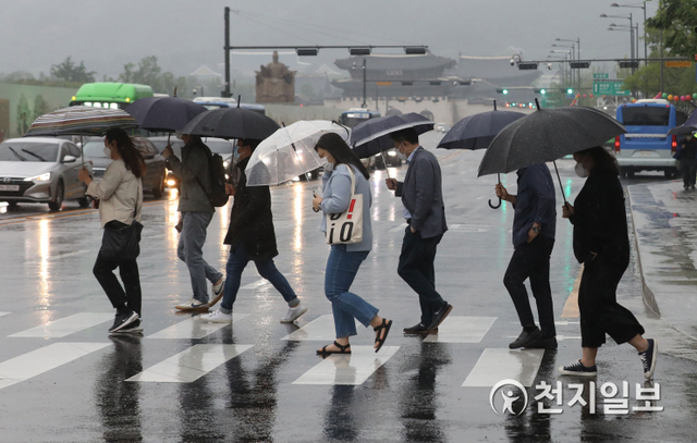 [천지일보=남승우 기자] 산발적이고 강한비가 내린 28일 오전 서울 종로구 광화문 네거리에서 시민들이 우산을 쓴 채 출근길을 서두르고 있다. ⓒ천지일보 2021.5.28