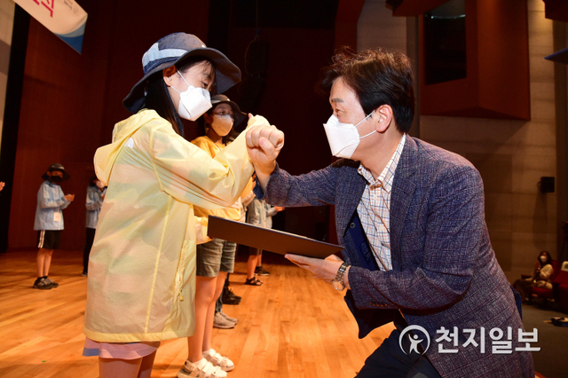 [천지일보 진주=최혜인 기자] 조규일 진주시장이 19일 진주미래인재학습지원센터에서 열린 진주성 어린이 해설사 수료식에서 한 수료생과 주먹인사를 하고 있다.이날 조규일 시장은 “진주성 해설사 양성은 지역 어린이가 직접 참여해 우리의 소중한 문화유산에 대한 자부심과 긍지를 가지는데 큰 의미가 있다”며 “앞으로 진주를 대표하는 어린이해설사로서 열심히 활동해주길 바란다”고 격려했다. (사진 제공: 진주시) ⓒ천지일보 2021.6.20