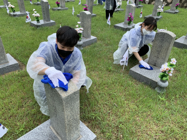 bhc치킨의 해바라기 봉사단 5기 2조가 지난 18일 국립서울현충원을 방문해 묘역 정화 봉사를 진행하고 있다. (제공: bhc치킨)