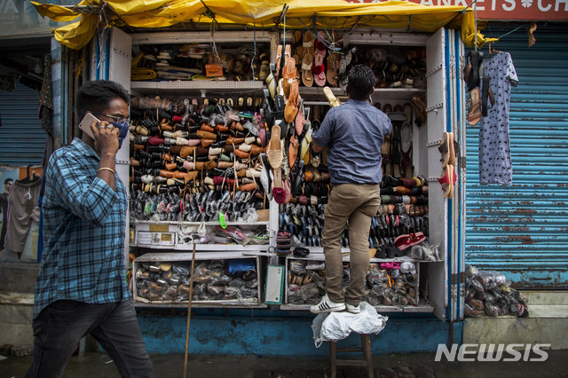 [가우하티=AP/뉴시스]9일(현지시간) 인도의 코로나19 규제가 일부 완화되면서 가우하티에서 한 신발가게 주인이 신발을 정리하고 있다.