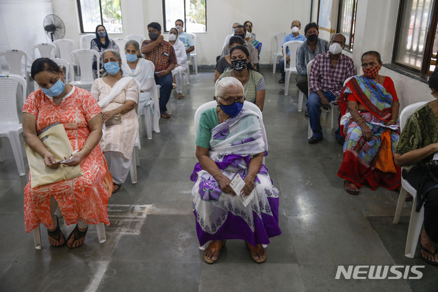 [뭄바이=AP/뉴시스]22일(현지시간) 인도 뭄바이의 한 코로나19 백신 접종소에서 주민들이 백신 접종 순서를 기다리고 있다.