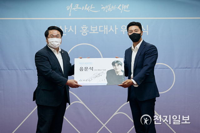 오세현 아산시장이 22일 시청 상황실에서 음문석에게 홍보대사 위촉패와 홍보대사 명함을 전달하고 있다. (제공: 아산시) ⓒ천지일보 2021.6.25