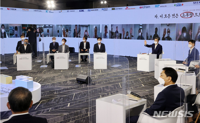 문재인 대통령이 2일 서울 강남구 코엑스에서 열린 대한민국 소재·부품·장비산업 성과 간담회에서 화상으로 참석한 소부장들에게 인사를 하고 있다. (출처: 뉴시스)