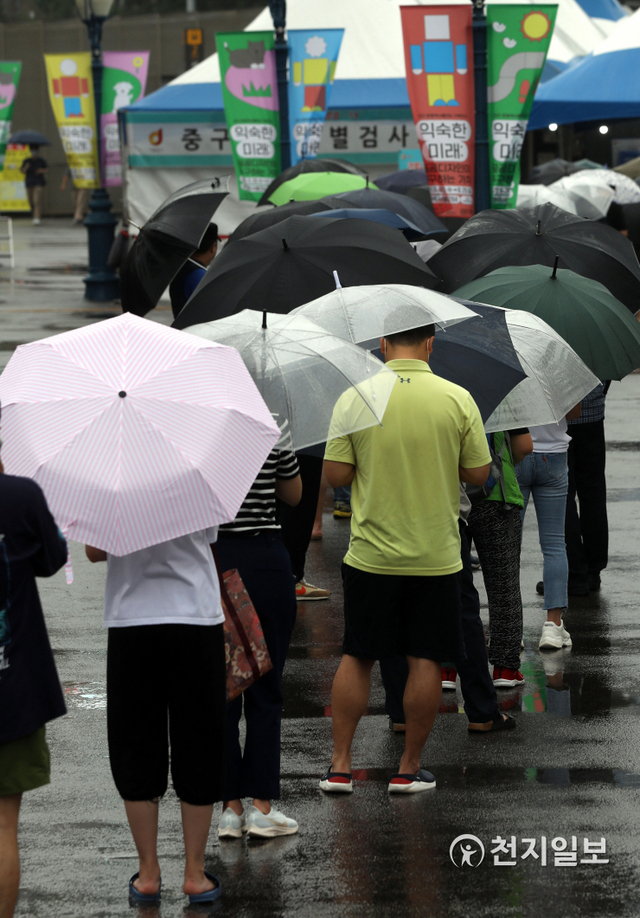 [천지일보=남승우 기자] 신종 코로나바이러스 감염증(코로나19) 신규 확진자가 743명으로 집계된 4일 오전 서울역 광장에 마련된 임시 선별검사소에서 시민들이 우산을 쓴 채 줄을 서서 코로나19 검사를 기다리고 있다. ⓒ천지일보 2021.7.4