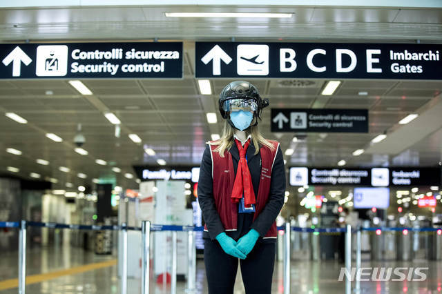 [로마=AP/뉴시스]6일(현지시간) 이탈리아 로마 레오나르도 다빈치 국제공항에서 한 근로자가 '스마트 헬멧' 스캐너를 착용하고 승객의 체온을 측정하고 있다.