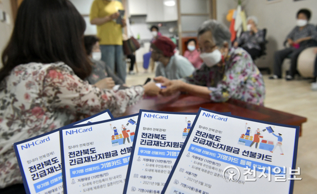 장수군이 전북긴급재난지원금 배부가 시작된 5일 장수군 장수읍 중동마을회관에서 군민들의 신원을 확인 후 긴급재난지원금을 배부하고 있다. (제공: 장수군) ⓒ천지일보 2021.7.5