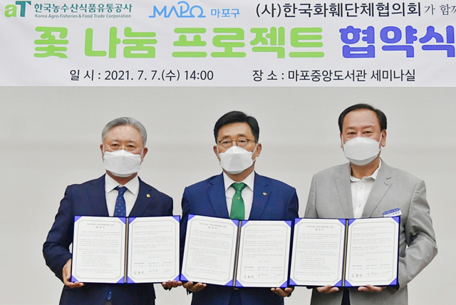 한국농수산식품유통공사(aT)와 서울 마포구청, ㈔한국화훼단체협의회가 7일 마포중앙도서관에서 꽃을 활용한 사회공헌 및 ESG경영 실천을 위한 업무협약을 체결하고 기념촬영을 하고 있다. (제공: 한국농수산식품유통공사) ⓒ천지일보 2021.7.7