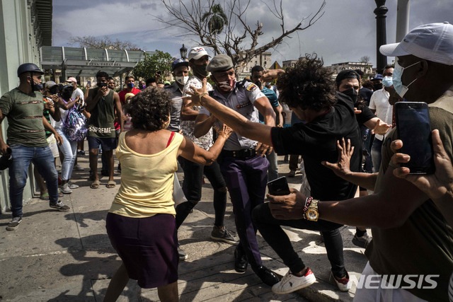 [아바나=AP/뉴시스] 11일(현지시간) 쿠바 수도 아바나에서 반정부 시위가 열려 시위대와 경찰이 충돌하고 있다. 이날 코로나19 확산으로 인한 식량 부족과 높은 식료품 가격 등에 항의하는 시위대가 쿠바 곳곳에서 거리로 몰려나왔다.