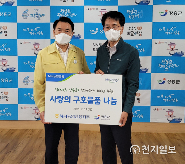 지난 13일 손병환 NH농협금융지주 회장(오른쪽)이 정종순 장흥군수와 호우피해를 입은 농가와 이재민을 위한 구호물품 전달 후 기념촬영을 하고 있다. (제공: NH농협금융지주) ⓒ천지일보 2021.7.14