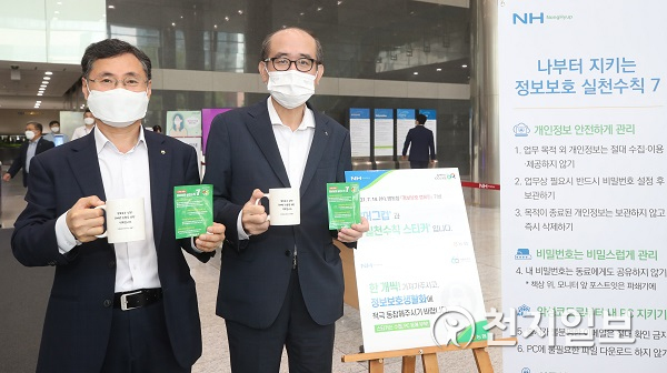 유찬형 농협중앙회 부회장(오른쪽)과 김현우 IT전략본부장(왼쪽)이 임직원 실천수칙과 머그컵을 들고 정보보호 생활화를 의미하는 기념촬영을 하고 있다. (제공: 농협) ⓒ천지일보 2021.7.14
