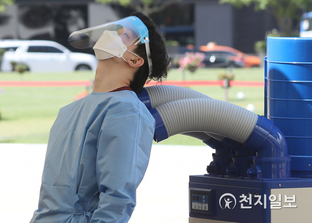 [천지일보=남승우 기자] 전국적으로 찜통더위가 이어지고 있는 16일 오전 서울광장에 마련된 임시 선별검사소에서 한 관계자가 냉풍기 앞에서 더위를 식히고 있다. 방역당국에 따르면 신종 코로나바이러스 감염증(코로나19) 신규 확진자가 1536명으로 집계됐다. ⓒ천지일보 2021.7.16