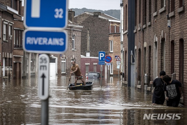 16일(현지시간) 벨기에 리에주 앙쿠르에서 한 남성이 침수된 침수된 길가를 따라 배를 젓고 있다. (출처: 뉴시스)
