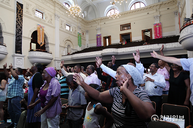 2012년 12월  15일 집회에서 감명을 받은 참석자들이 일어나 찬양과 기도를 올리고 있다. (제공: HWPL) ⓒ천지일보 2021.7.19