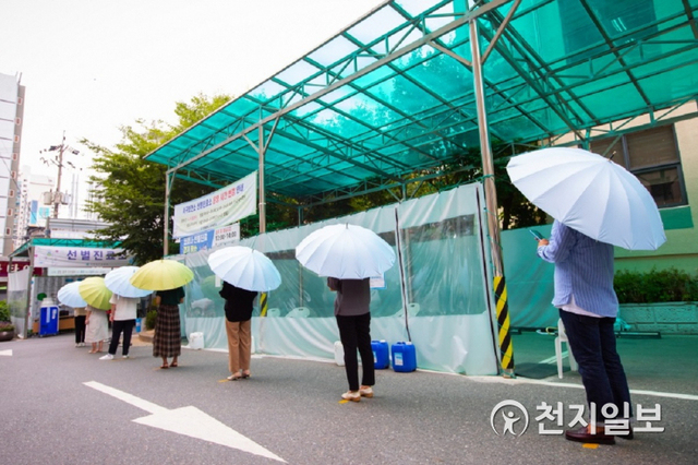 무더위 속  코로나19  검사를 받기 위해 선별검사소를 찾은 인천 서구 주민들이 구에서 제공하는 우산을 펼쳐 든 채 줄을 서 있다. (제공: 인천 서구청) ⓒ천지일보 2021.7.19