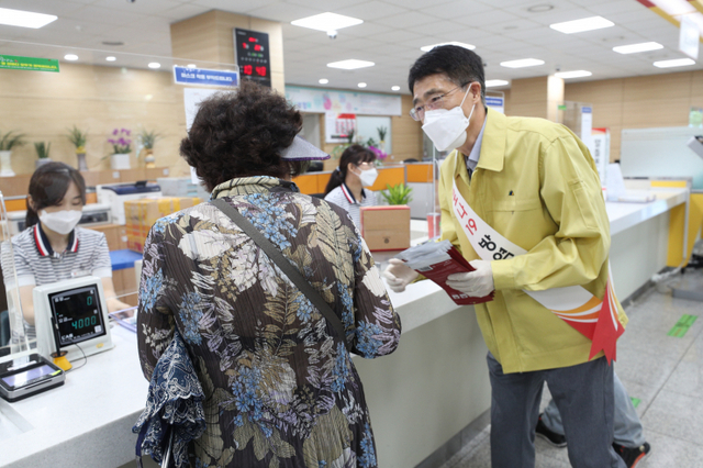 박종석 우정사업본부장이 22일 오전 인천남동우체국을 찾은 고객에게 마스크를 나눠주며 정부의 사회적 거리두기에 동참해 줄 것을 당부하고 있다. (제공: 우정사업본부) ⓒ천지일보 2021.7.22