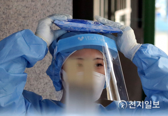 [천지일보=남승우 기자] 전국 대부분 지역에 폭염 특보가 발효된 23일 오전 서울 동작구 보건소에 마련된 선별진료소에서 한 의료진이 아이스팩을 머리에 얹고 더위를 식히고 있다. 방역당국에 따르면 이날 신종 코로나바이러스 감염증(코로나19) 신규 확진자는 1630명으로 집계됐다. ⓒ천지일보 2021.7.23