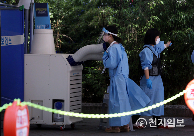 [천지일보=남승우 기자] 전국 대부분 지역에 폭염 특보가 발효된 23일 오전 서울 동작구 보건소에 마련된 선별진료소에서 한 의료진이 냉풍기 앞에 서서 더위를 식히고 있다. 방역당국에 따르면 이날 신종 코로나바이러스 감염증(코로나19) 신규 확진자가 1630명으로 집계됐다. ⓒ천지일보 2021.7.23