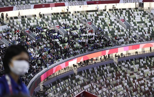 [도쿄(일본)=뉴시스]  23일 2020 도쿄올림픽 개회식이 열리는 도쿄 신주쿠 국립경기장 관중석에 관계자들이 앉아 있다. 언뜻 보면 사람이 많은듯하지만 이는 사람들이 있는 것처럼 보이게 하기 위해 다른 색의 좌석 덮개를 씌운 것이다.