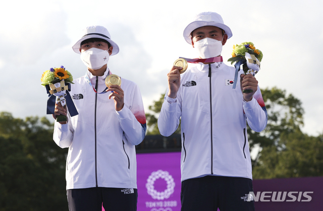[도쿄(일본)=뉴시스] 대한민국 양궁 대표팀 안산과 김제덕이 24일 오후 일본 도쿄 유메노시마 양궁장에서 열린 2020 도쿄올림픽 양궁 남녀혼성단체전에서 금메달을 차지한 뒤 포즈를 취하고 있다. 2021.07.24.
