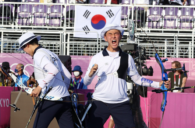 [도쿄(일본)=뉴시스] 대한민국 양궁 대표팀 안산과 김제덕이 24일 오후 일본 도쿄 유메노시마 양궁장에서 열린 2020 도쿄올림픽 양궁 남녀혼성단체전 결승에서 승리하며 금메달을 확정지은 뒤 기뻐하고 있다. 2021.07.24.