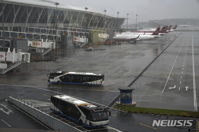 [상하이=AP/뉴시스] 6호 태풍 인파의 상륙을 앞두고 모든 항공기 운항이 취소된 저장(浙江)성 상하이의 푸둥 국제공항에서 25일 발이 묶인 항공기와 버스들이 멈춰 서 있다. 2021.7.25