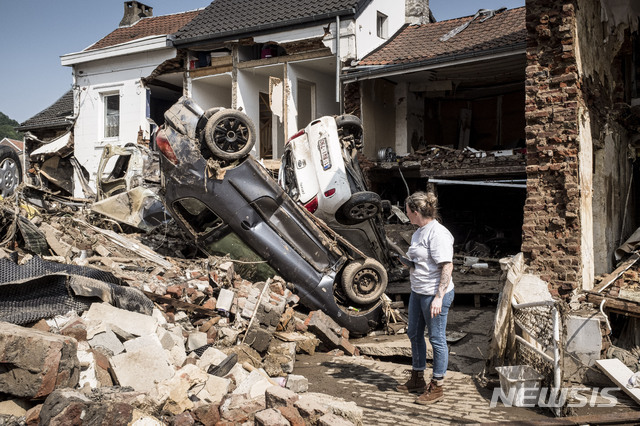 19일(현지시간) 벨기에 리에주에서 한 주민이 침수로 파손된 차와 집을 살피고 있다. 벨기에와 독일에서 발생한 대홍수로 하천과 도로가 격류로 변해 차량이 휩쓸리고 주택이 붕괴한 후 피해 지역 주민들은 청소와 복구 작업을 이어가고 있다. (출처: 뉴시스)