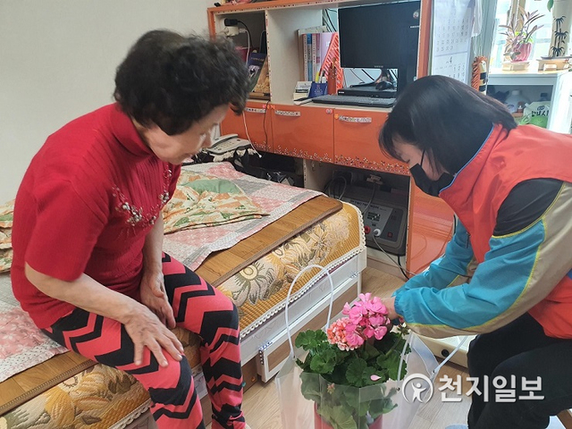 의정부시가 소외된 1인가구를 위해 사회적 고립가구에 대한 맞춤형 서비스를 지원하는 가운데 담당자가 독거노인에게 꽃이 핀 화분을 전해주고 있다. (제공: 의정부시) ⓒ천지일보 2021.7.26