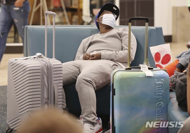 미 플로리다주 올랜도 국제공항에서 한 여행객이 마스크를 쓰고 대기하고 있는 모습. (출처: 뉴시스)