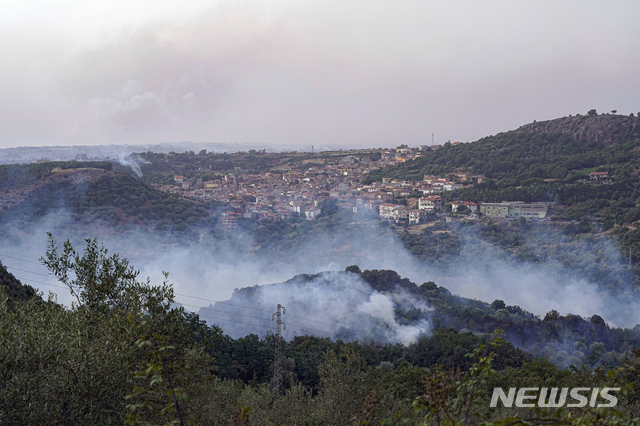 [사르데냐=AP/뉴시스] 26일(현지시간) 이탈리아 사르데냐섬 쿨리에리 지역에서 숲과 건물이 화염에 뒤덮여 있다.