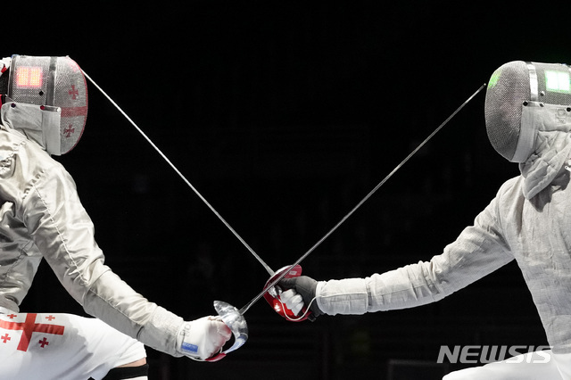 오상욱(오른쪽)이 24일 2020 도쿄올림픽 펜싱 남자 사브르 8강전에서 산드로 바자제(조지아)를 상대하고 있다. (출처: 뉴시스)
