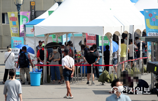 [천지일보=박준성 기자] 폭염이 계속되는 24일 서울역 광장에 마련된 임시선별진료소에서 코로나19 검사를 기다리던 시민들이 검사소 앞에 설치된 햇볕 가림천막에서 더위와 햇볕을 피하고 있다. ⓒ천지일보 2021.7.24