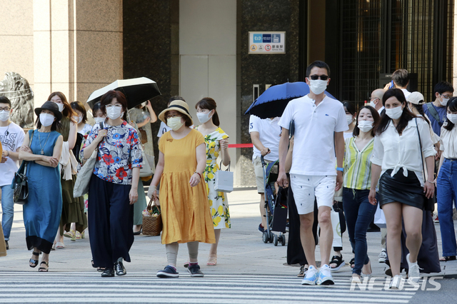 [도쿄=AP/뉴시스] 일본 수도 도쿄에서 24일 코로나19 예방을 위해 마스크를 착용한 시민들이 횡단보도를 건너고 있다.