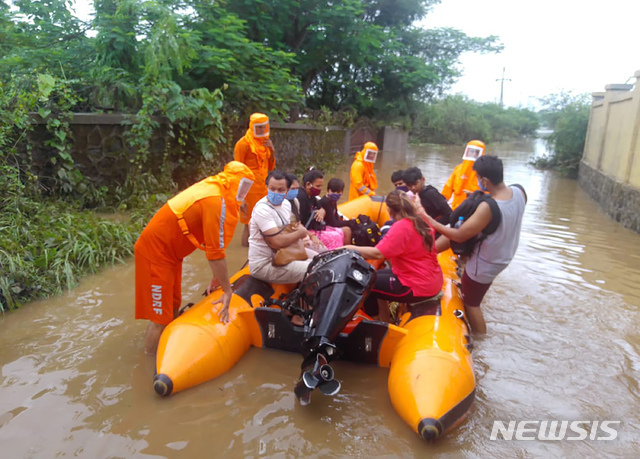 [비완디=AP/뉴시스] 22일(현지시간) 인도 마하라슈트라주 뭄바이 외곽 비완디에서 인도 국가재난대응군(NDRF) 구조대가 홍수로 고립된 주민들을 보트에 태워 구조하고 있다.