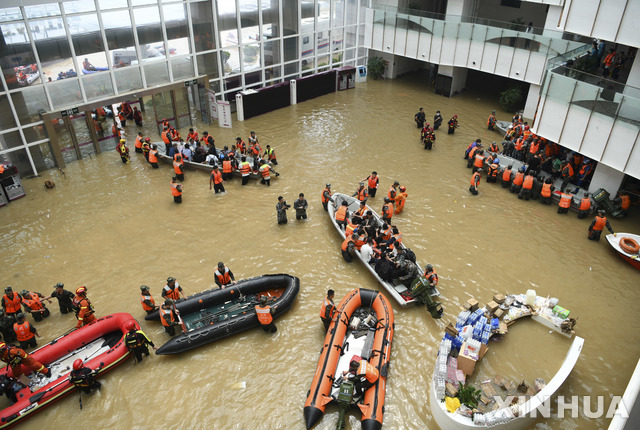 [정저우=신화/뉴시스] 22일(현지시간) 중국 허난성 정저우 중무 현에 있는 푸와이 중앙 심혈관병원 로비에서 구조대가 환자들을 이송하고 있다. 최근 내린 기록적인 폭우로 홍수가 발생해 주변 도로와 병원 로비가 침수되면서  병원에 고립됐던 환자, 환자 가족 및 의료진이 이날부터 구조대의 도움으로 대피하기 시작해 지금까지 약 5000명이 대피한 것으로 전해졌다. 2021.07.23.