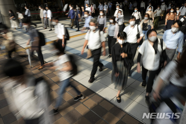 [도쿄=AP/뉴시스] 12일 출근 시간 일본 도쿄 시나가와역에서 마스크를 쓴 시민들이 통로를 걸어가고 있다.