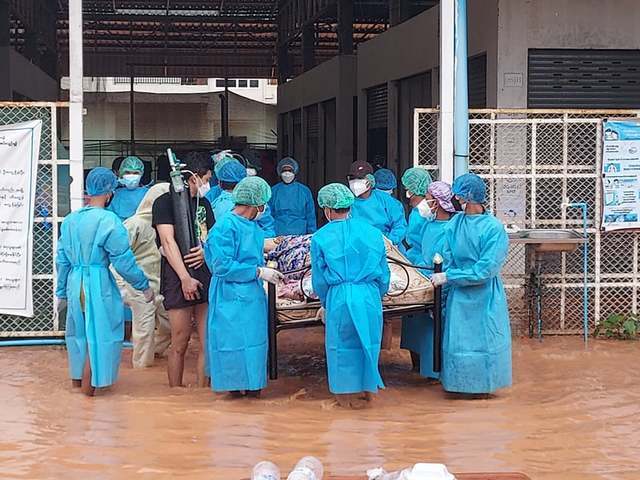서울=뉴시스]미얀마 카렌주에서 발생한 홍수로 코로나19 센터가 물에 잠겼다. 의료진은 환자와 장비 등이 물에 잠기지 않도록 환자와 침대, 장비를 통째로 들어 옮기고 있다. (사진 = 카렌공보센터 페이스북)