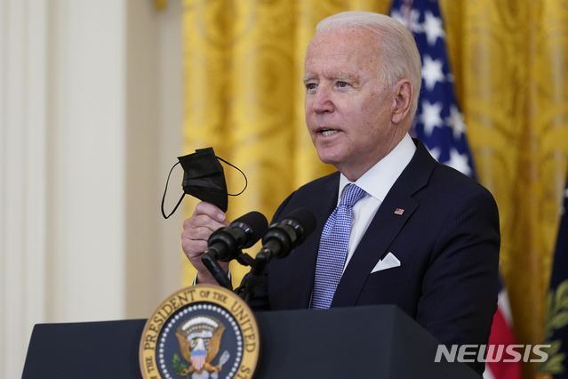 워싱턴=AP/뉴시스] 조 바이든 미국 대통령이 29일(현지시간) 백악관 이스트룸에서 코로나19 관련 연설을 하면서 마스크를 들고 있다.