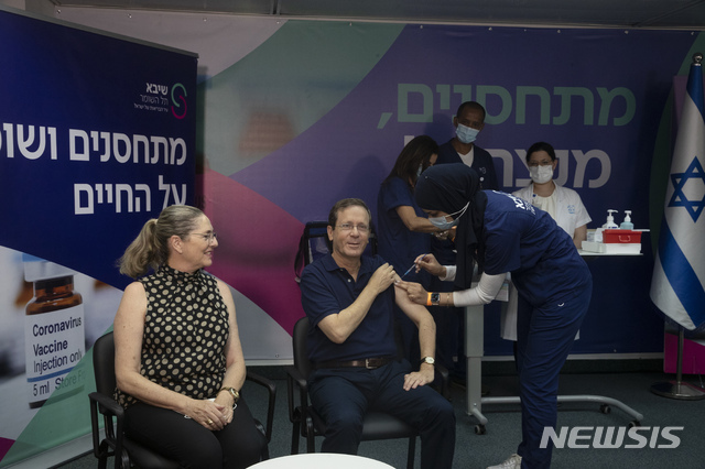 [AP/뉴시스] 30일 이스라엘의 헤르초크 대통령이 부인 미카엘 여사가 지켜보는 가운데 코로나19 백신 3번째 주사를 맞고 있다