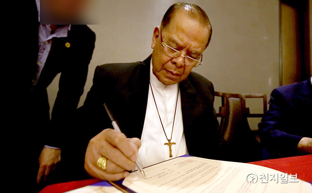 2014년 1월 24일 페르난도 카펠라 필리핀 민다나오 다바오 교구 전 가톨릭 대주교가 민다나오 민간 평화협정식에서 전쟁종식 세계평화 협약서에 서명하고 있다. (제공:HWPL) ⓒ천지일보 2021.8.11