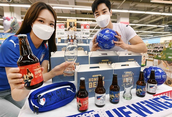 13일 모델들이 홈플러스 동수원점에서 ‘수원삼성블루윙즈 병맥주잔 기획팩’을 선보이고 있다. (제공: 홈플러스)