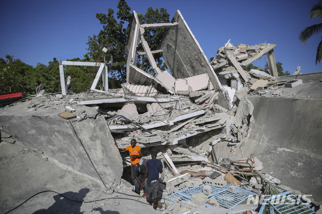 [레카이=AP/뉴시스] 14일(현지시간) 아이티에서 규모 7.2의 지진이 발생해 레카이 주민들이 무너진 집 잔해 속에서 생존자를 찾고 있다.