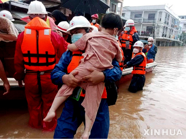 지난달 29일 미얀마 남동부 미야와디에 몬순 홍수가 덮쳐 구조대원들이 어린 아이를 구조하고 있다. (출처: 뉴시스)