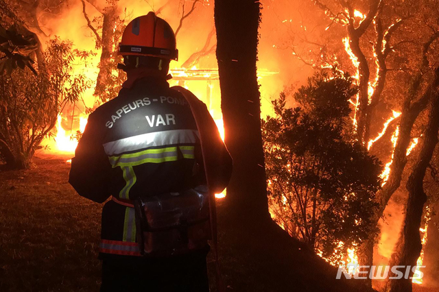 [툴롱=AP/뉴시스] 프랑스 남동부 바르 지역에서 대형 산불이 발생해 17일 새벽(현지시간) 한 소방관이 툴롱에서 진화 작업을 하고 있다. 소방 당국은 전날 밤 툴롱에서 시작된 산불로 소방대원 약 900명이 투입돼 화재를 진화하고 있으며 지역 주민과 휴가객 등 6000여 명이 대피했다고 전했다. 2021.08.17.