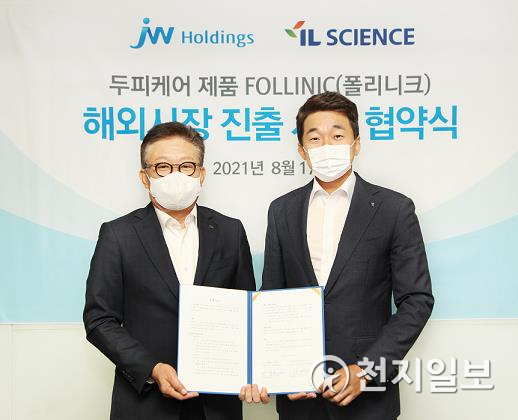 한성권 JW홀딩스 대표(왼쪽)와 송성근 아이엘사이언스 대표가 협약서에 서명한 뒤 기념촬영하고 있다. (제공: JW홀딩스) ⓒ천지일보 2021.8.18