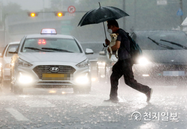 [천지일보=남승우 기자] 소나기가 내린 27일 오후 서울역 인근에서 강아지를 품에 안은 시민이 비를 피해 발걸음을 재촉하고 있다. ⓒ천지일보 2021.6.27